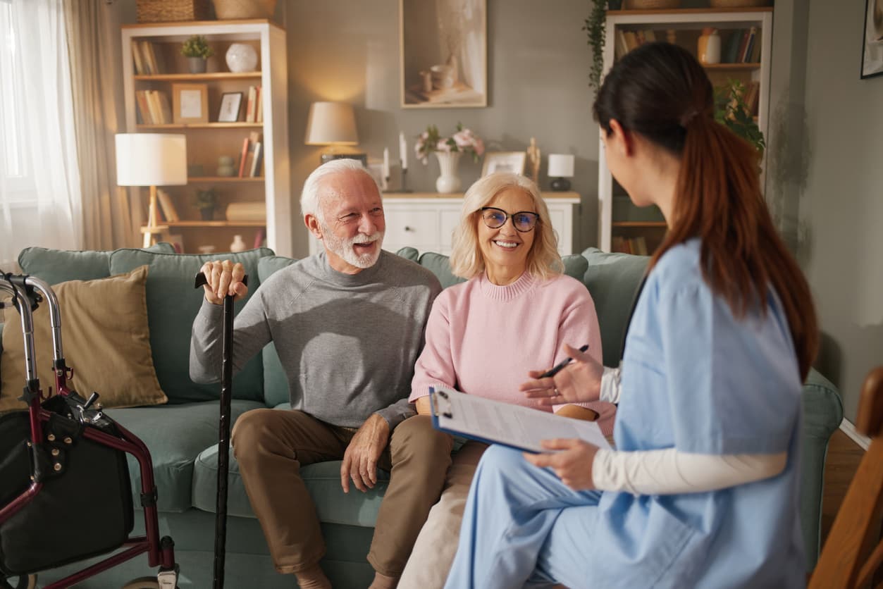 Nurse talking with an older couple during a home care visit
