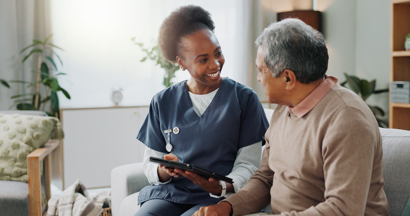 Registered nurse speaking with a client during a home nursing visit